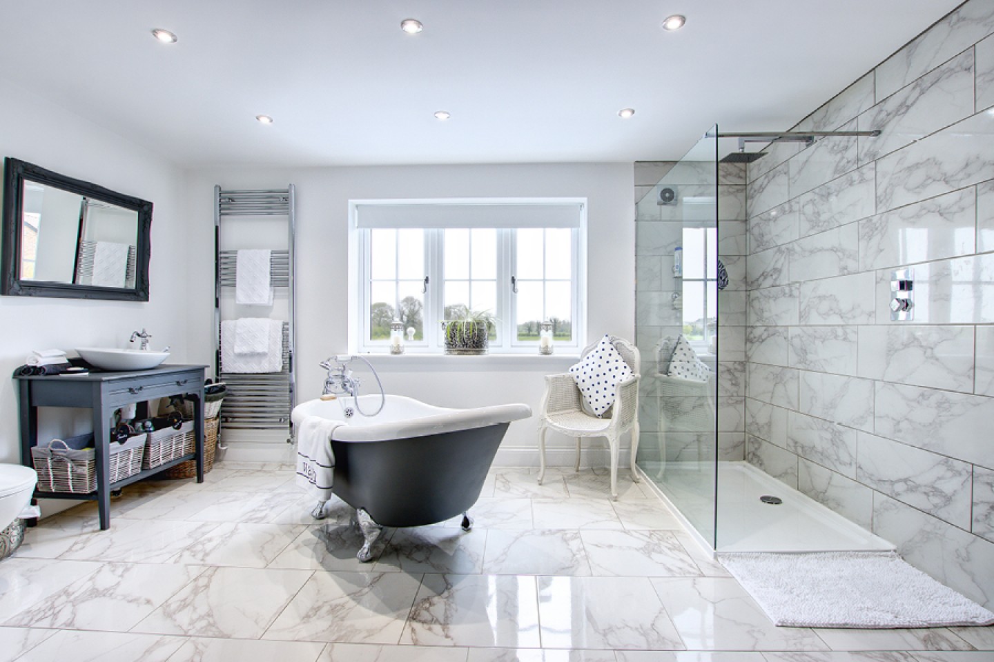 large en-suit bathroom with marble grey and white tiles, walk in shower and free-standing bath 